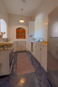 uma grande cozinha com armários brancos e um frigorífico em El Gouna Rihana House sea view em Hurghada