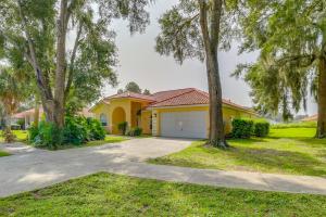 a yellow house with a garage and trees at Sunny Inverness Home with Private Pool! in Inverness