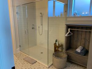 Ocean Front Private Suite في فيكتوريا: دش مع باب زجاجي في الحمام