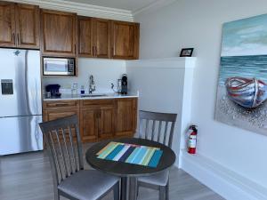 a kitchen with a table and chairs and a refrigerator at Ocean Front Private Suite in Victoria