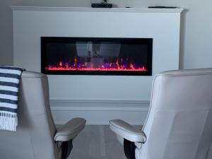 a living room with two chairs and a fireplace at Ocean Front Private Suite in Victoria