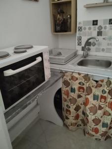 a kitchen with a stove and a sink at SPILIOTICA CENTRAL APARTMENTS in Fira