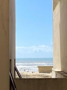 - une vue sur la plage depuis un bâtiment dans l'établissement Apto a 20 metros da praia, à Capão da Canoa