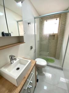 Un baño con lavabo, inodoro y ducha. en Apto a 20 metros da praia, en Capão da Canoa 11 fotos más