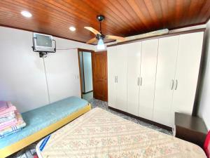 Cette chambre comprend un lit et un ventilateur de plafond. dans l'établissement Apto a 20 metros da praia, à Capão da Canoa