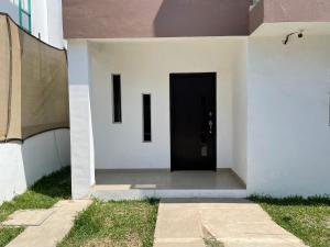uma porta preta do lado de um edifício branco em Casa SOL em Cobos