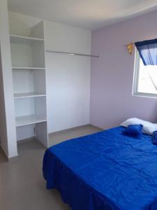um quarto com uma cama azul e uma janela em Casa SOL em Cobos