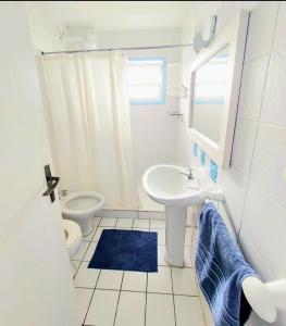 a white bathroom with a sink and a toilet at Pousada Los Casarones in Florianópolis