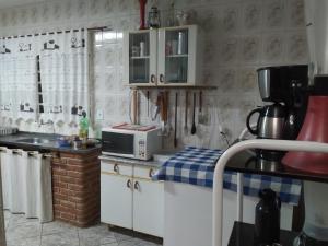 Chácara meu doce في سوكورو: مطبخ مع دواليب بيضاء وميكرويف