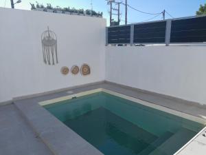 a swimming pool on the side of a white wall at SPILIOTICA VILLAS AND APARTMENTS in Imerovigli