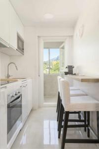 uma cozinha branca com electrodomésticos brancos e cadeiras brancas em Selva Blanca de Villanua em Villanúa