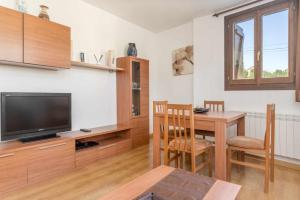 sala de estar con TV y mesa con sillas en Apartamento Montañes Castiello de Jaca, en Castiello de Jaca