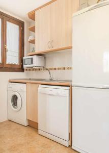 cocina con nevera blanca y lavavajillas en Apartamento Montañes Castiello de Jaca, en Castiello de Jaca