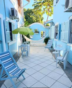 a patio with chairs and tables and an umbrella at Pousada Los Casarones in Florianópolis