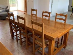 a wooden dining room table with wooden chairs at Maison de charme rénovée proche Verdun, idéal randos, 3 ch, jardin, terrasse, cuisine équipée - FR-1-585-48 in Forges-sur-Meuse