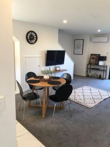 a dining room with a table and black chairs at Close to Arena and not far away from Railway station onsite park rare to find in Christchurch