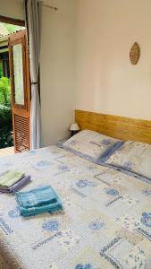 a bed with a blue and white comforter on it at Suites surf house itamambuca in Ubatuba