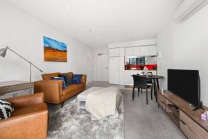 een woonkamer met een bank, een tv en een tafel bij 1BR APT Albert Lake& Crown& DFO& MEC in Melbourne