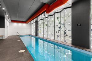 een zwembad met een muur van ramen bij 1BR APT Albert Lake& Crown& DFO& MEC in Melbourne