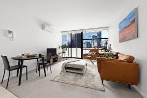 een woonkamer met een bank en een tafel bij 1BR APT Albert Lake& Crown& DFO& MEC in Melbourne