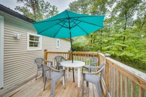 einen Tisch und Stühle auf einer Terrasse mit einem Sonnenschirm in der Unterkunft Cozy Virginia Escape with Deck, Grill and Fire Pit! in Luray