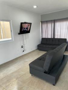sala de estar con sofá y TV de pantalla plana en Casa LUNA, en Cobos
