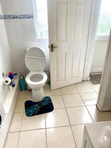 uma casa de banho branca com um WC e uma porta em 3 bedroom peaceful house (5 people maximum) em Morriston