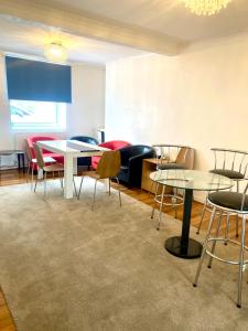 uma sala de jantar com mesas e cadeiras e um sofá em 3 bedroom peaceful house (5 people maximum) em Morriston