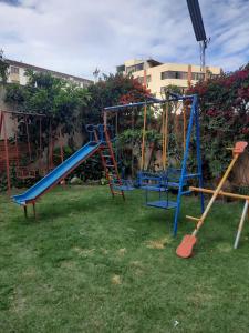 un parque infantil con un tobogán azul en un patio en Recidencia El Hogar, en Cochabamba