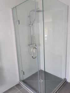 una doccia con porta in vetro in bagno di Lovely House in Central Papatoetoe ad Auckland
