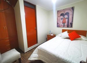 1 dormitorio con 1 cama con puerta roja en Bon Repos Arequipa, en Arequipa