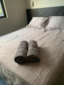 ein Bett mit zwei Kissen und ein Buch darauf in der Unterkunft Arpoar Suítes Hotel Unidade 120 in João Pessoa