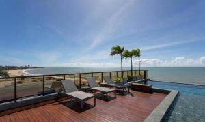 a deck with chairs and a view of the ocean at Arpoar Suítes Hotel Unidade 120 in João Pessoa