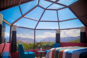 een slaapkamer met een groot raam met uitzicht op de bergen bij Sky Dome Peru in Cuzco