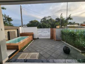 un patio trasero con piscina y bañera de hidromasaje en Casa Sunstay Garden com piscina en Bombinhas