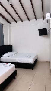 Zimmer mit 2 Betten und einem TV an der Wand in der Unterkunft HOTEL BOUTIQUE CRISTOFF in Apartadó