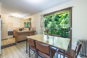 a kitchen with a table and chairs and a large window at Pin High in Blackheath