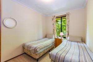 two beds in a room with a window at Pin High in Blackheath