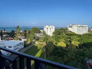 un balcón con vistas a una ciudad con palmeras y edificios en Apartamentos Classy Reef alado de la playa en San Andrés