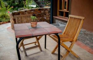 stół z dwoma krzesłami i doniczką w obiekcie Fleur Lodge w mieście Carhuaz
