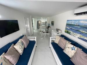 sala de estar con 2 sofás y TV de pantalla plana en Apartamentos Classy Reef alado de la playa en San Andrés