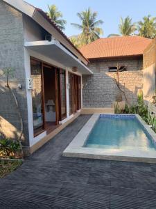una casa con piscina frente a una casa en Pranajaya loka private villa, en Tejakula