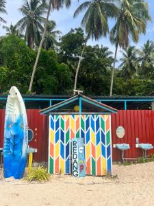 a colorful beach shack and a surfboard on the beach at Redang Campstay in Redang Island
