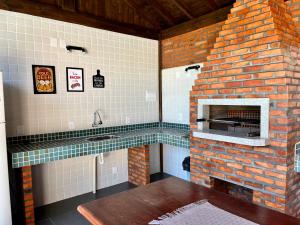 瓜德丁堡的住宿－Recanto das Palmeiras，厨房设有砖砌壁炉和水槽。