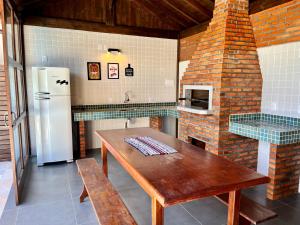 瓜德丁堡的住宿－Recanto das Palmeiras，厨房配有木桌和冰箱。