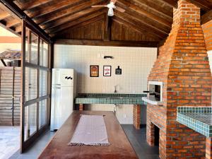 瓜德丁堡的住宿－Recanto das Palmeiras，厨房配有冰箱和砖墙
