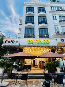 un hôtel avec des tables et des chaises devant un bâtiment dans l'établissement Golden Sun Hotel Apartments, à Hô-Chi-Minh-Ville