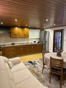 a living room with a white couch and a kitchen at Castelo de Paiva, São Martinho de Sardoura in Castelo de Paiva