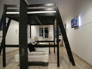 a loft bed with a desk and a couch in a room at Apartament Jagielloński in Krakow