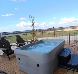 bañera de hidromasaje en una terraza con vistas a un campo en Whitetail Meadows Ranch, en Johnson City